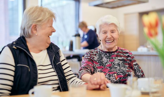 Zwei Seniorinnen freuen sich über die Gemeinschaft in der Tagespflege Viersen. 