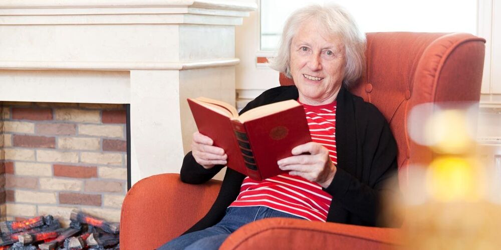 Bewohnerin liest im Aufenthaltsraum des Hauses St. Martinus