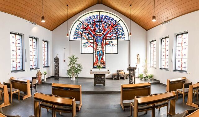 Innenraum einer Kapelle in welchem z.B. einige Sitzenbänken und ein Altar befinden.