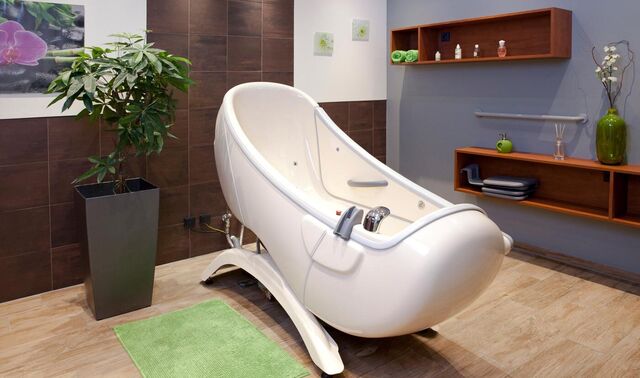 Geräumiger Raum mit einer Wellnessbadewanne in der Mitte. 